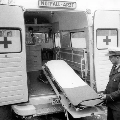 Rettungssanitäter zieht Trage aus dem geöffneten Notarztwagen mit medizinischer Ausstattung.