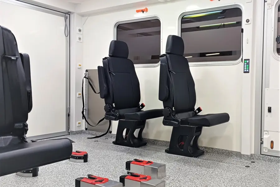 Innenansicht eines Scania-Intensivtransportwagens mit seitlich montierten Sitzen und Tragenhalterungen.