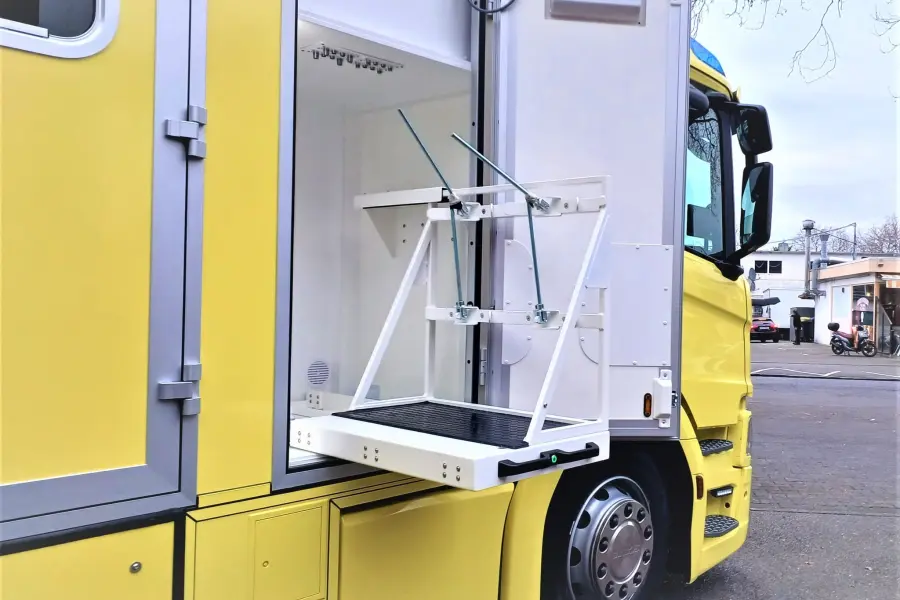 Seitliches Staufach eines Scania-ITW mit herausgeklapptem Halterungssystem, außen am Fahrzeug.