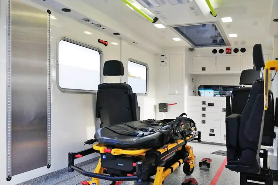 Innenraum eines Sprinter-Intensivtransportwagens mit Trage, Sitzen und medizinischer Ausstattung.