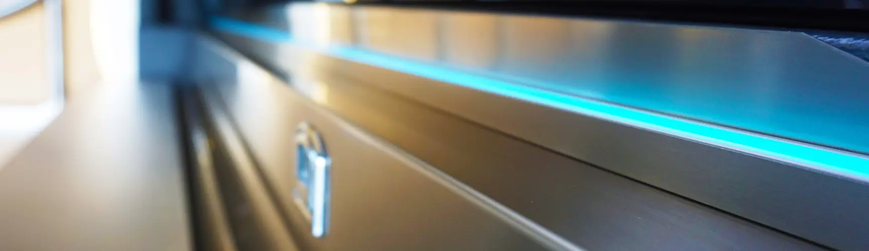 Detailaufnahme einer Edelstahlführung mit blauer Lichtleiste in einem Bestattungswagen.