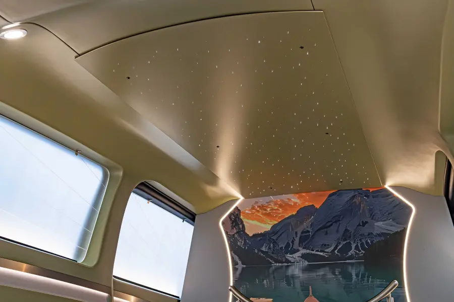 Optional setzen ein glitzernder LED-Sternenhimmel und seitliche Ambientebeleuchtung besondere Akzente und tauchen den Sargraum in ein warmes, einladendes Licht.