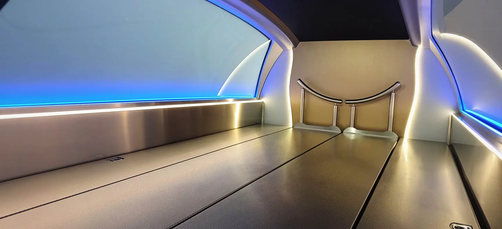 Innenraum eines modernen Bestattungswagens mit Edelstahlflächen, LED-Beleuchtung und Sargauflage.