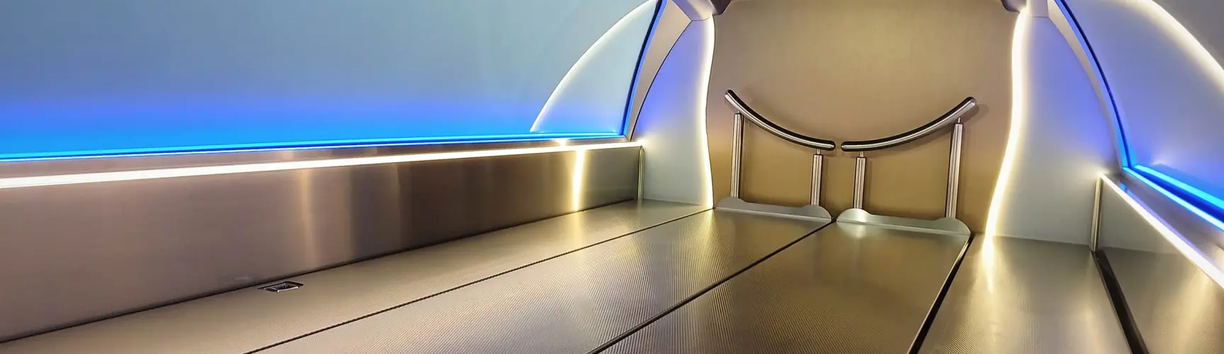 Innenraum eines modernen Bestattungswagens mit Edelstahlflächen, LED-Beleuchtung und Sargauflage.