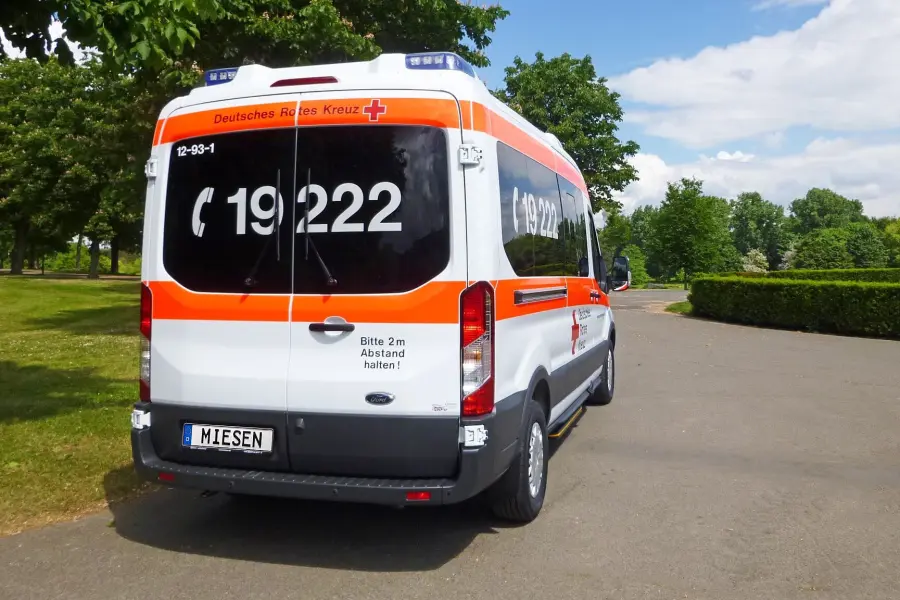 Rettungswagen des Deutschen Roten Kreuzes mit Warnmarkierung und Notrufnummer 19 222.