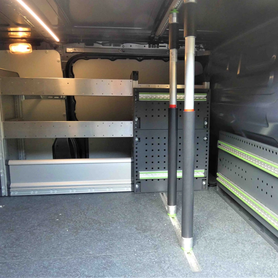 Innenraum eines Transporters mit grauen Regalsystemen, Befestigungsschienen und Teleskopstangen zur Ladungssicherung.