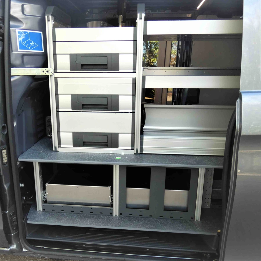Seitenansicht eines Transporters mit eingebautem Regalsystem und Schubladen für Werkzeuge und Material.