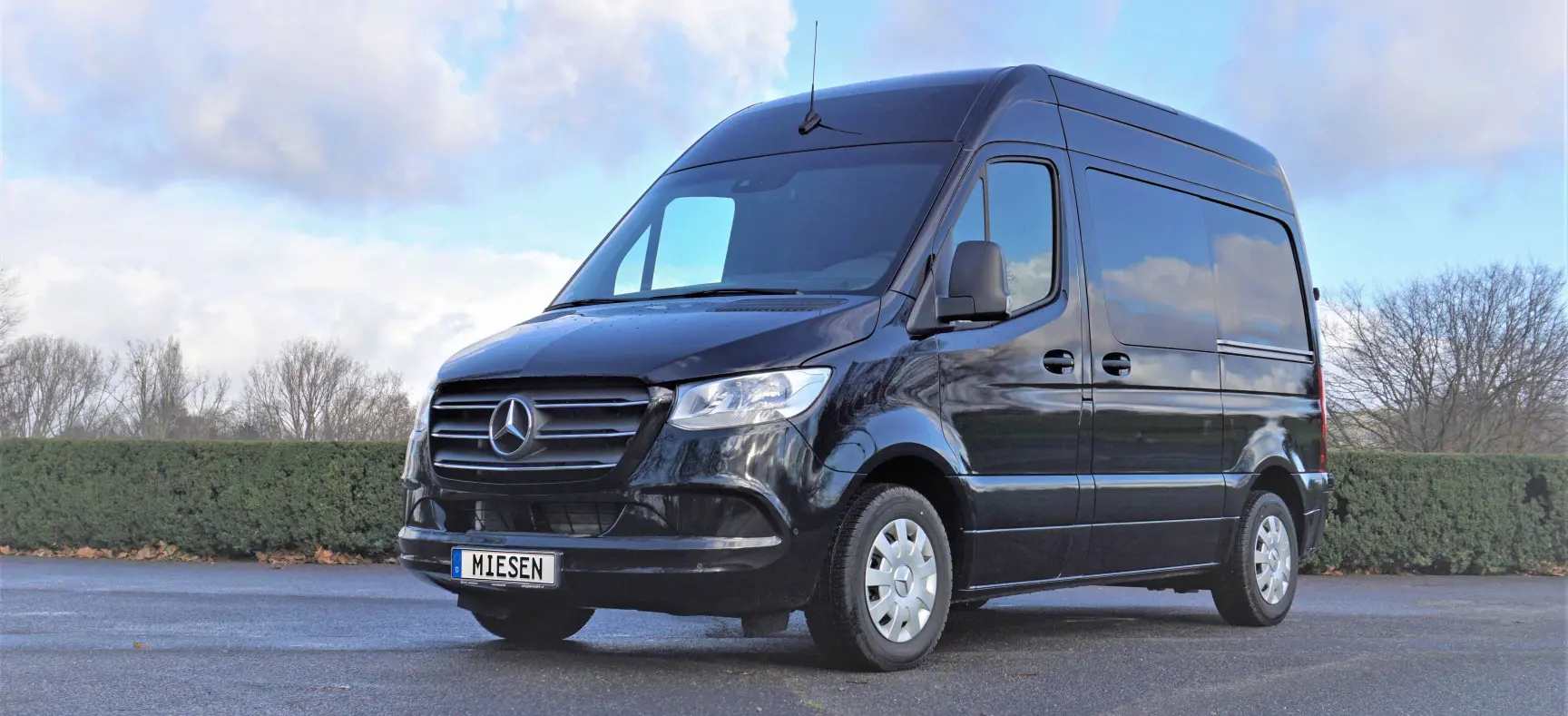 Auf dem Foto ist ein Mercedes Benz Sprinter in der Farbe schwarz zu sehen.