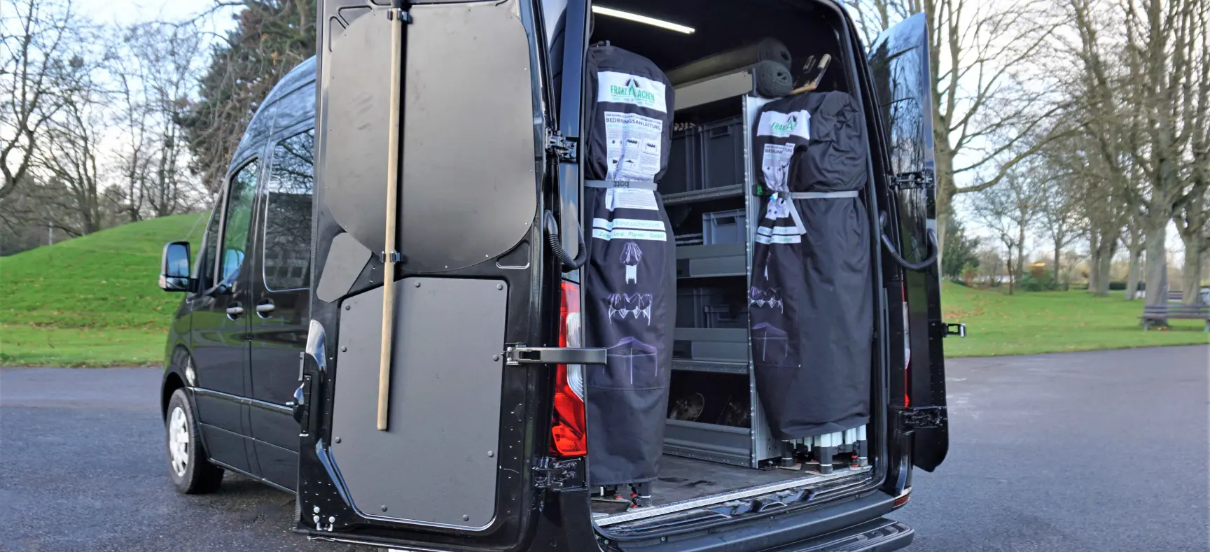Auf dem Foro sieht man das Fahrzeug mit geöffneten Heckflügeltüren. Im inneren sieht man ein Regalsystem, für das gesamte Zubehör.