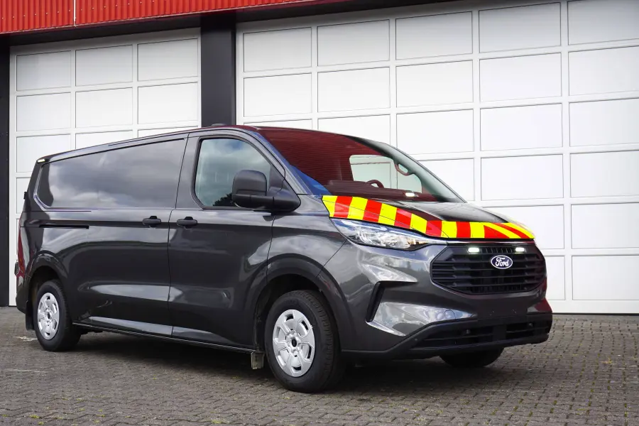 Bestattungswagen mit Kühltechnik und eingeschalteten weißen Blitzleuchten im Kühlergrill und hinter der Windschutzscheibe