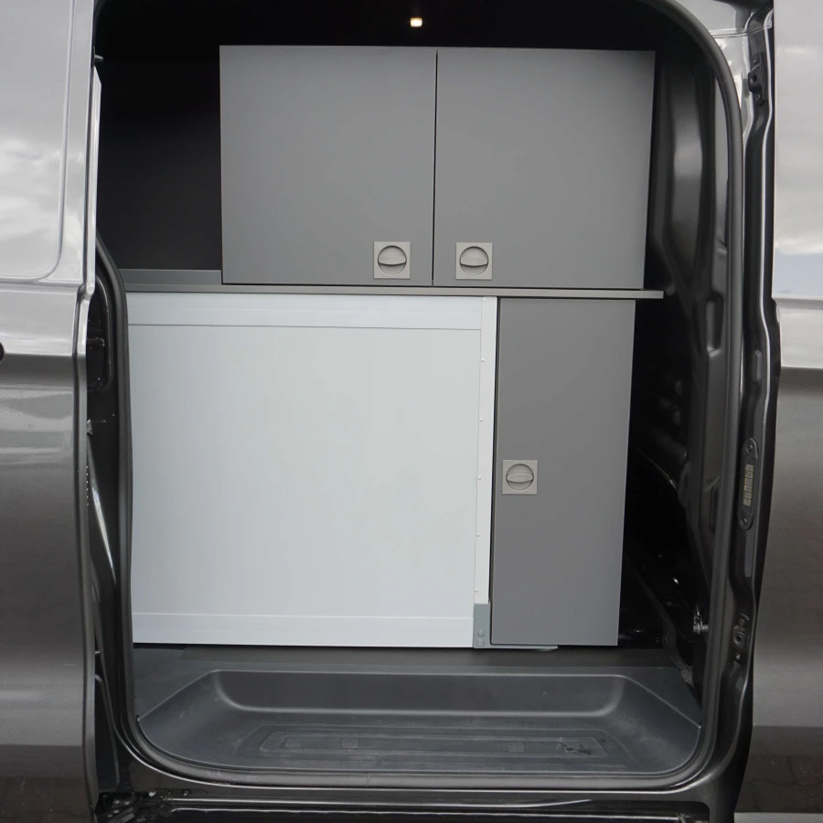 Seitliche Ansicht eines Fahrzeugs mit geöffneter Tür und grauem Stauraum- und Schranksystem im Innenraum.