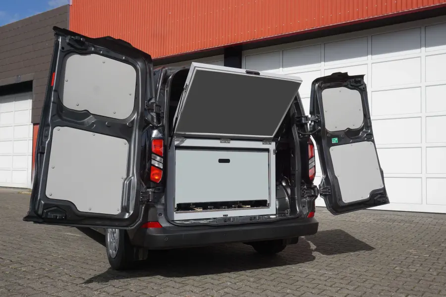 Offene Hecktüren eines schwarzen Transportfahrzeugs mit angehobenem Laderaumdeckel und Stauraum im Innenraum.