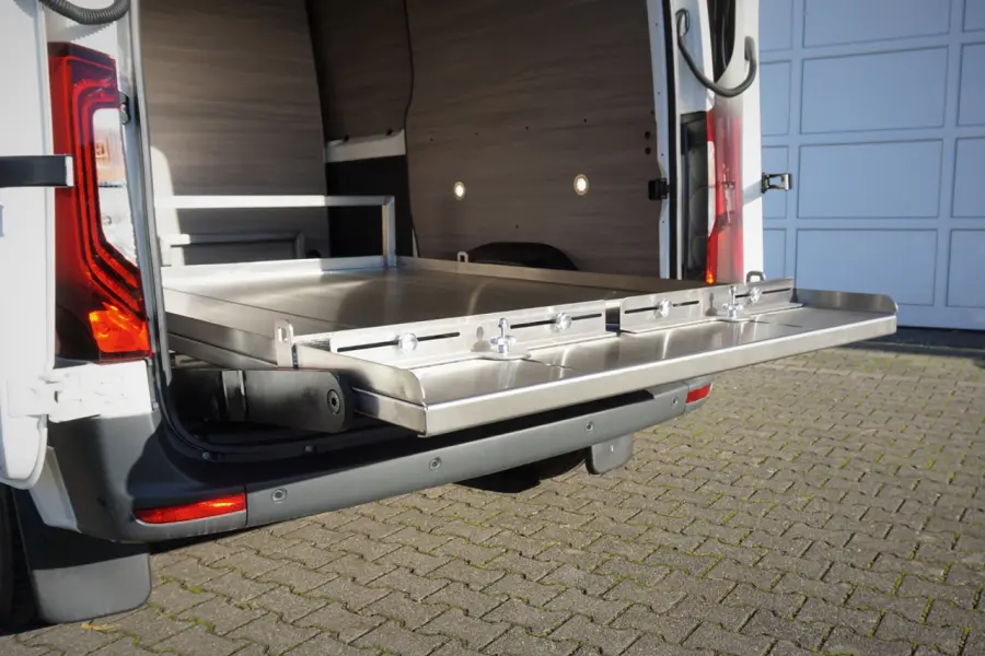 Ausgezogene Edelstahlplattform im Laderaum eines Transportfahrzeugs mit Holzverkleidung.