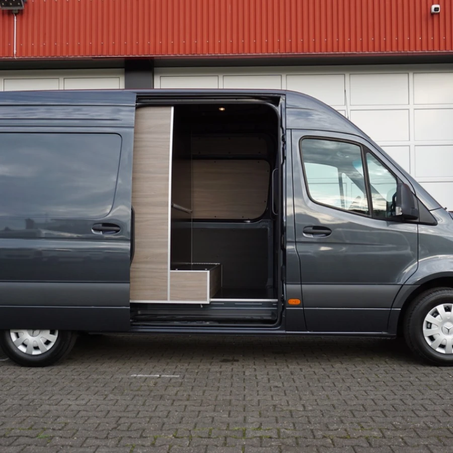 Seitenansicht eines dunkelgrauen Fahrzeugs mit geöffneter Schiebetür und modern ausgebautem Innenraum.