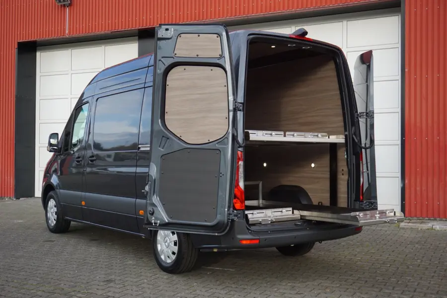 Offen stehender Transporter mit Holzverkleidung und ausziehbarer Ladefläche im Heckbereich.