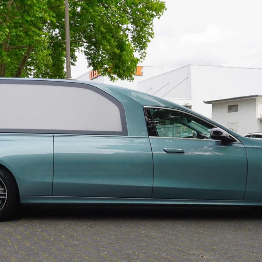 Seitliche Ansicht eines eleganten Bestattungsfahrzeugs in grün-metallic Lackierung.