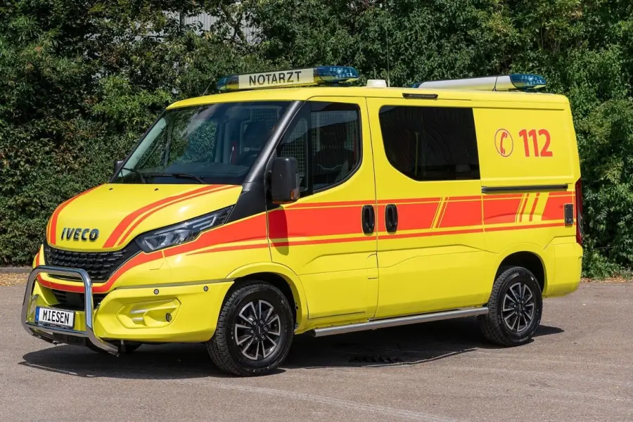 Gelber Notarzteinsatzwagen auf Iveco-Basis mit roter Beklebung und der Notrufnummer 112.