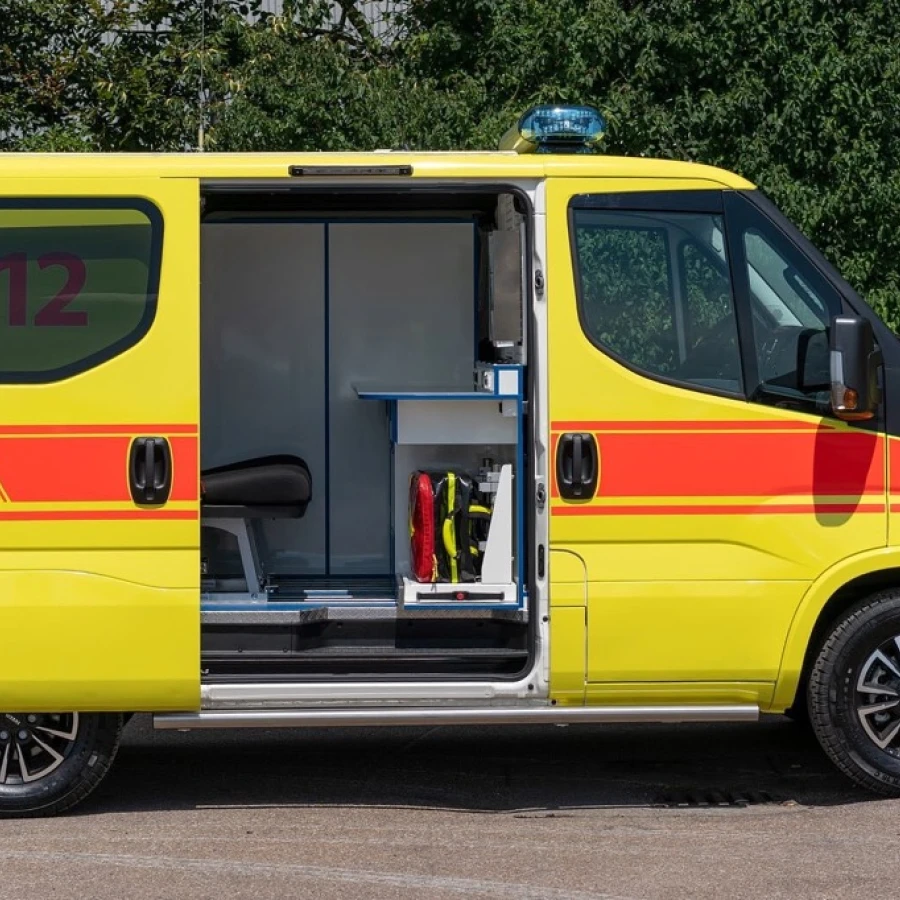Seitenansicht eines gelben Notarzteinsatzfahrzeugs mit geöffneter Tür und sichtbarer Innenausstattung mit medizinischer Ausrüstung.