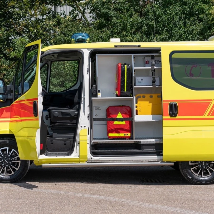 Seitenansicht eines gelben Notarzteinsatzfahrzeugs mit geöffneter Tür und sichtbarer Innenausstattung mit medizinischer Ausrüstung.