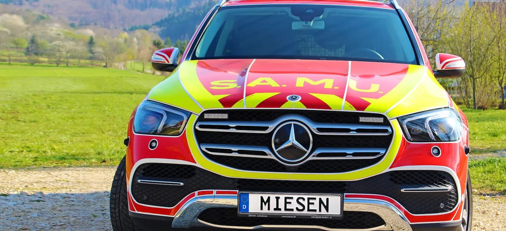 Frontansicht eines gelb-roten Einsatzfahrzeugs von Miesen mit SAMU-Beschriftung und Blaulicht.
