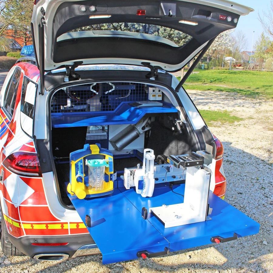 Heck eines Einsatzfahrzeugs mit ausziehbarem Arbeitstisch und montierter medizinischer Ausrüstung.