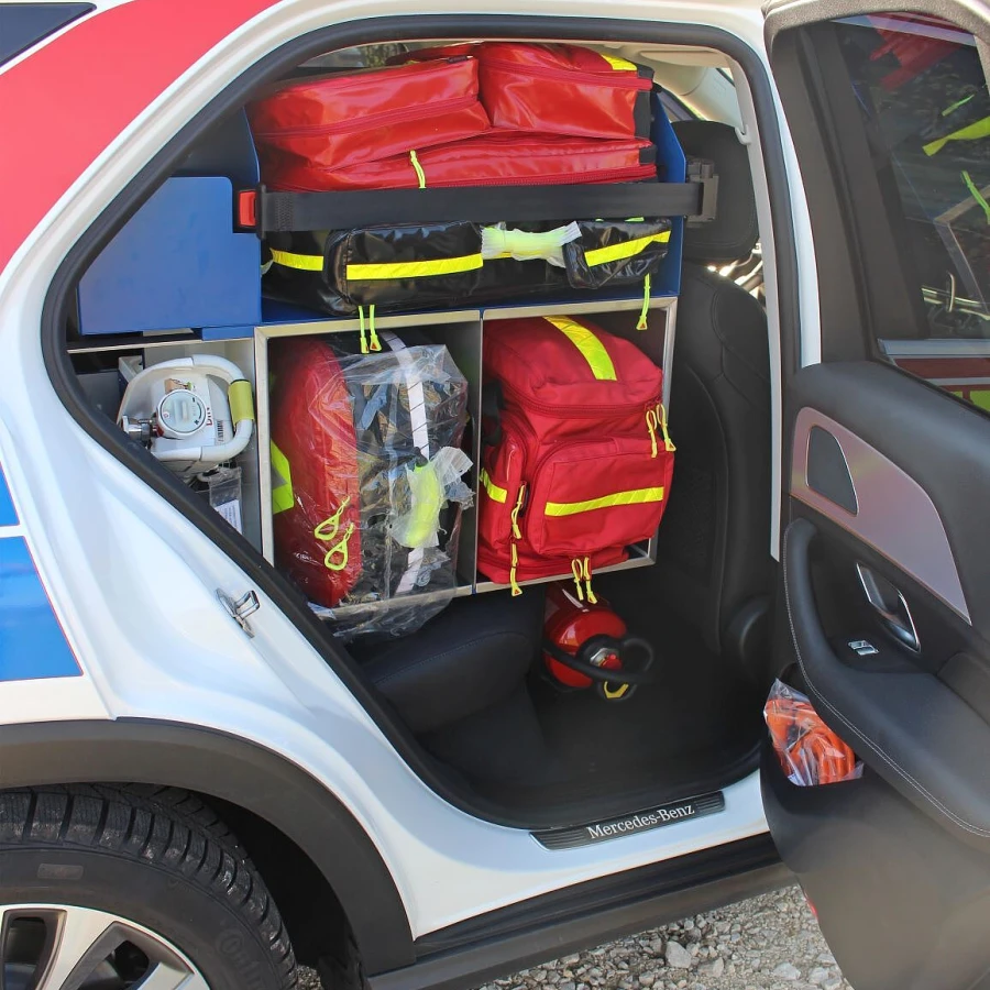 Blick in den seitlichen Stauraum eines Notarzteinsatzfahrzeugs mit mehreren Rettungsrucksäcken und medizinischem Equipment.