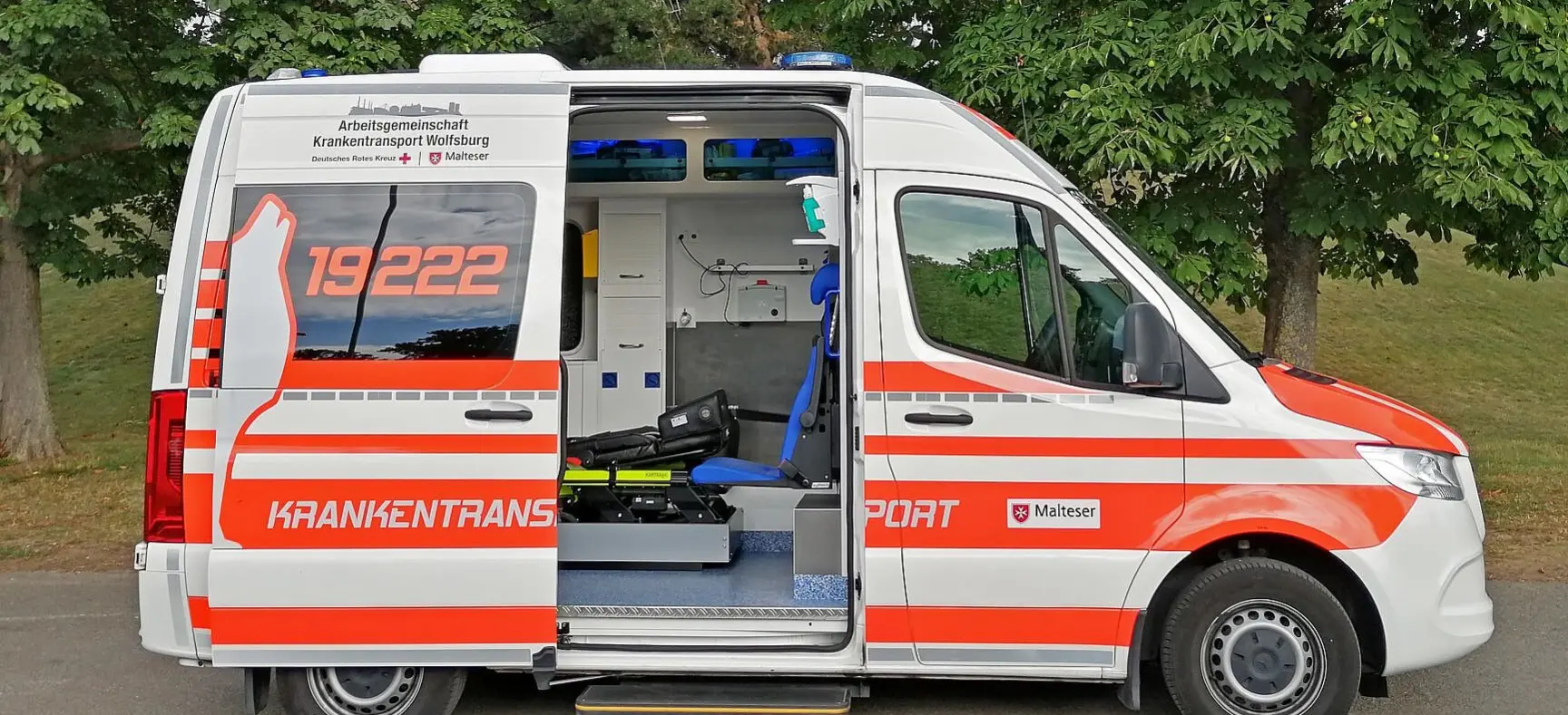 Krankentransportwagen mit offener Seitentür und Blick auf die Innenausstattung.