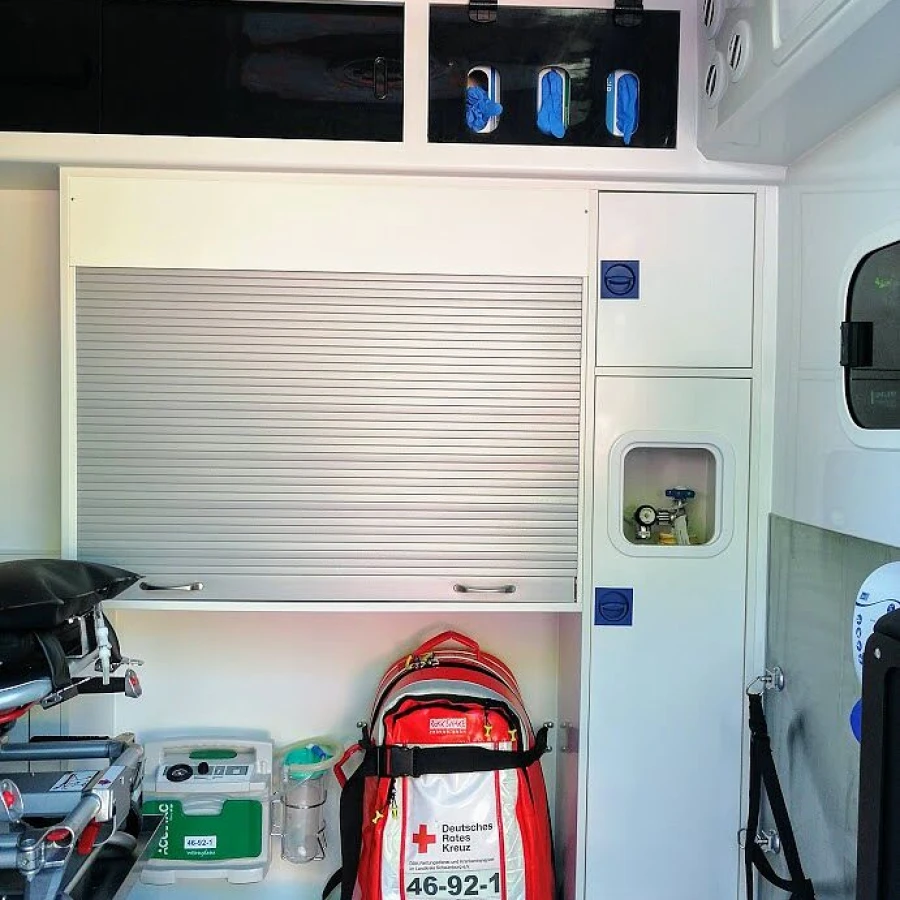 Innenansicht eines Rettungswagens mit Notfallrucksack des Deutschen Roten Kreuzes und medizinischer Ausstattung.