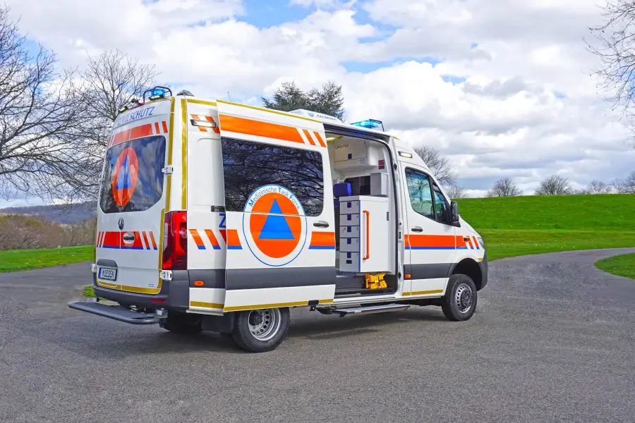 Zivilschutz-KTW mit geöffneter Tür auf Straße.
