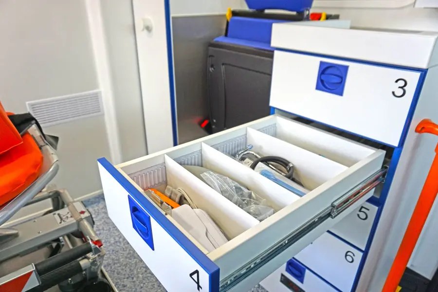 Geöffnete Schublade eines KTW mit Fächern und medizinischem Zubehör, darunter Kabel und Beatmungsschläuche.