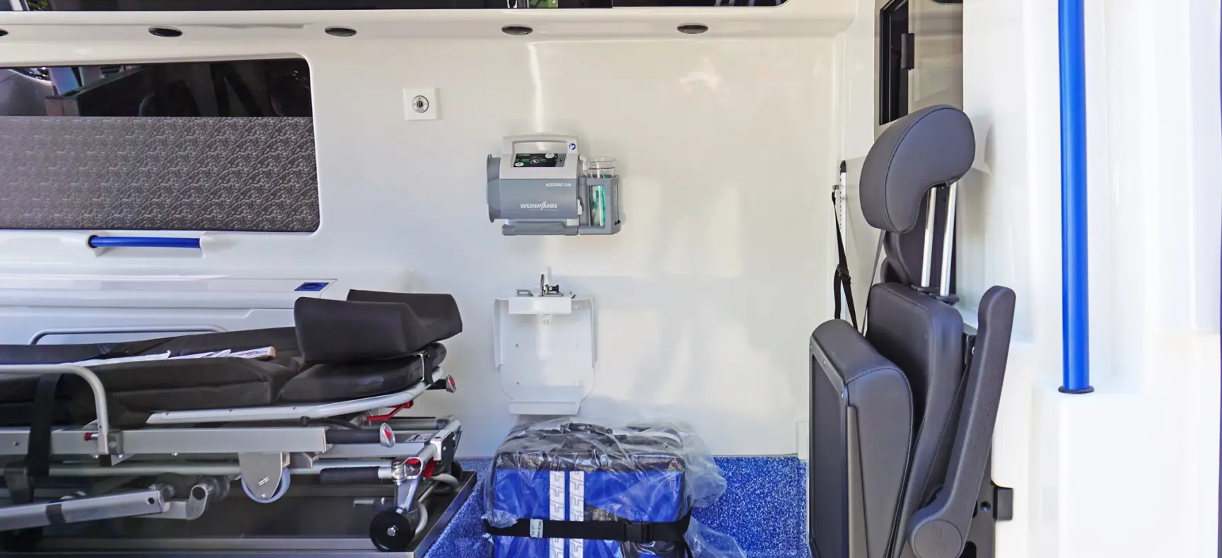 Innenansicht eines Krankentransportwagens mit Trage, Sitzplatz und medizinischer Ausstattung.