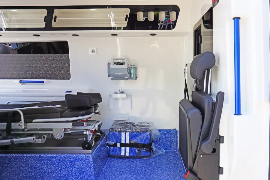 Innenansicht eines Krankentransportwagens mit Trage, Sitzplatz und medizinischer Ausstattung.