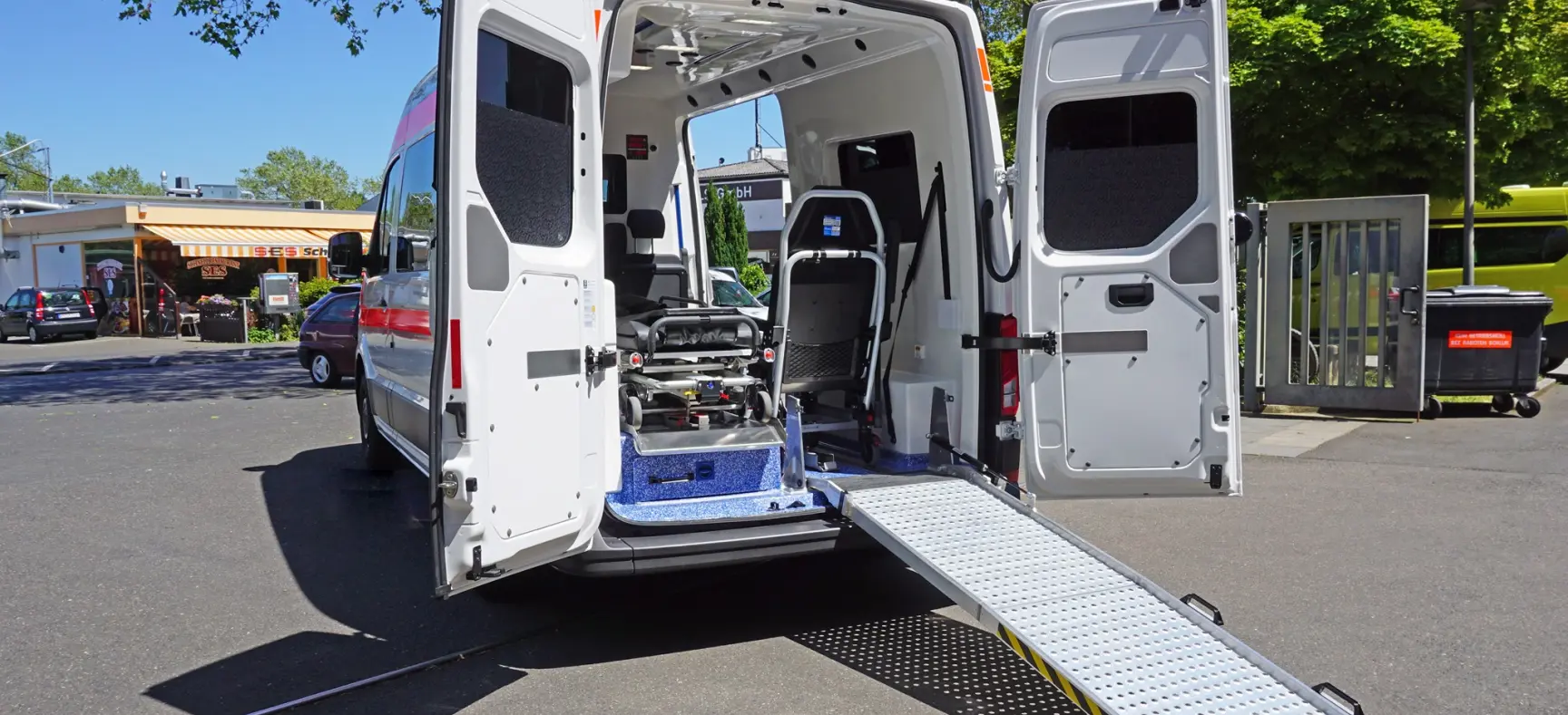 Heckansicht eines Krankentransportwagens mit geöffneter Rampe und moderner Innenausstattung.