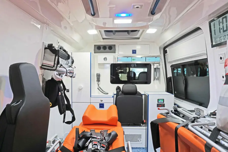 Innenraum eines modernen Krankenwagens mit Trage, Sitzplätzen und medizinischer Ausrüstung.