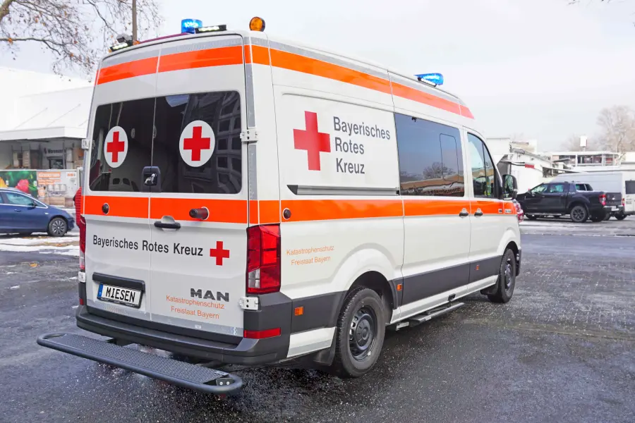 Rettungsfahrzeug des Bayerischen Roten Kreuzes mit Warnmarkierung und Blaulichtanlage.