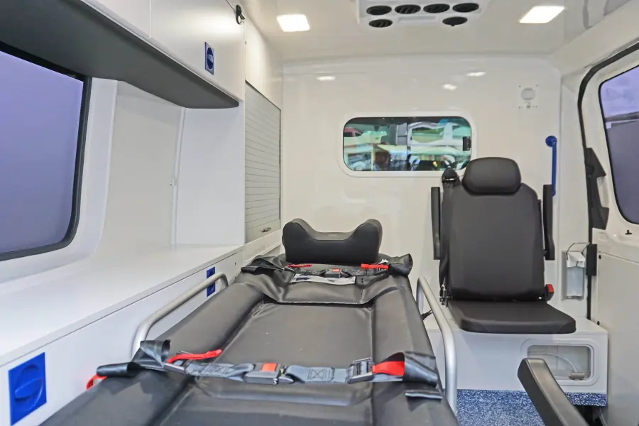 Innenraum eines KTW mit Trage, Sitzplatz für Begleitperson und Stauraum in modernem, hygienischem Design.