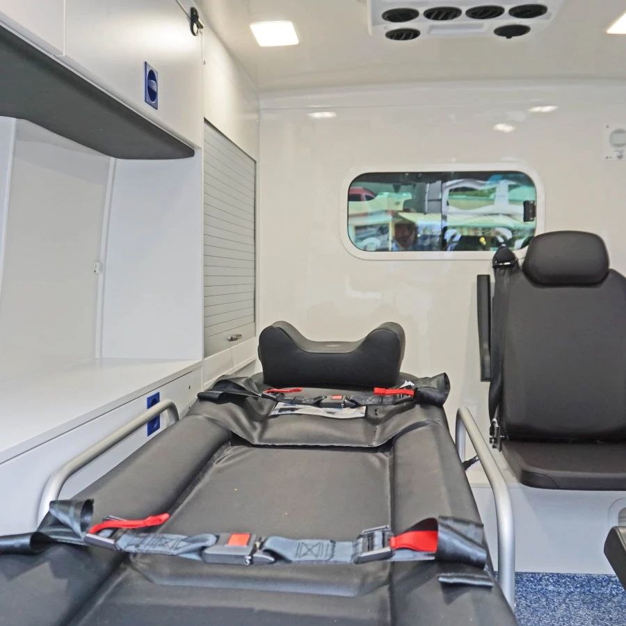 Innenraum eines Krankentransportwagens mit Trage und Sitzplatz für Begleitpersonal.