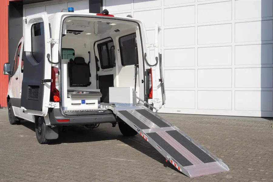 KTW mit geöffneter Hecktür und ausgeklappter Auffahrrampe zur einfachen Patientenaufnahme.