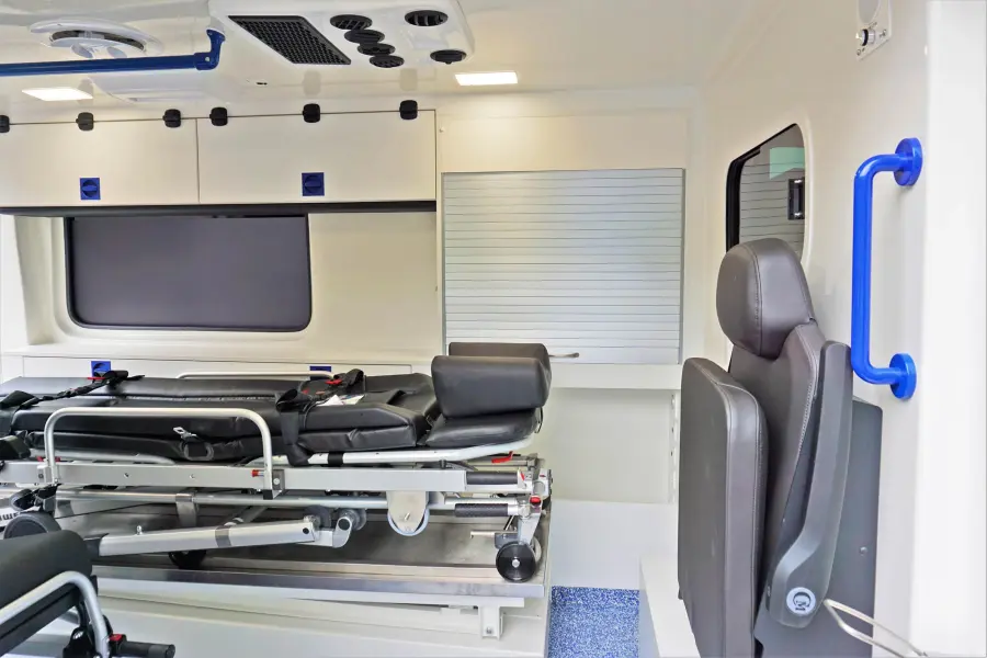Innenraum eines KTW mit Trage, Klappsitz und Stauraum.