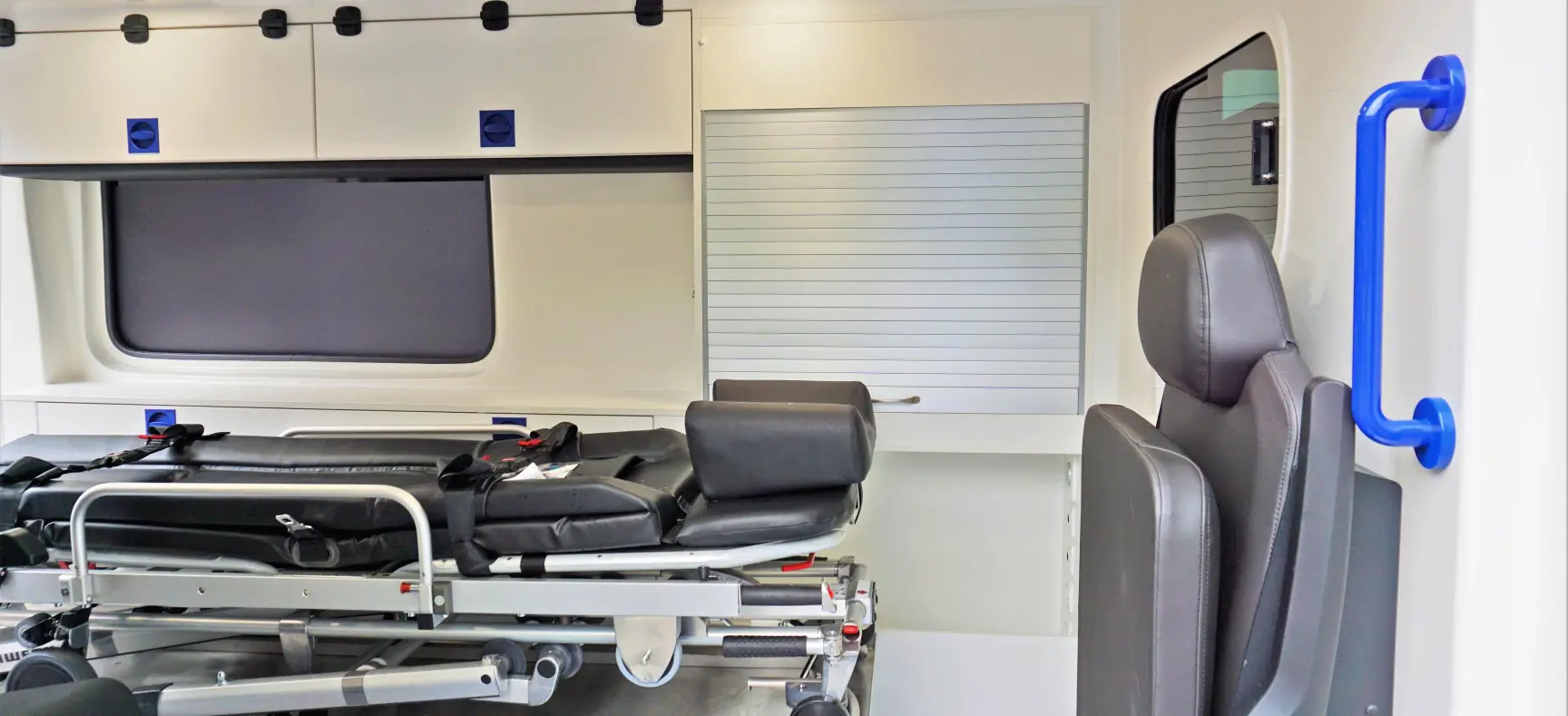 Innenraum eines KTW mit Trage, Klappsitz und Stauraum.