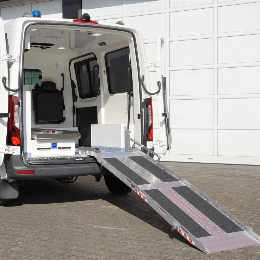 KTW mit geöffneter Hecktür und ausgeklappter Auffahrrampe zur einfachen Patientenaufnahme.