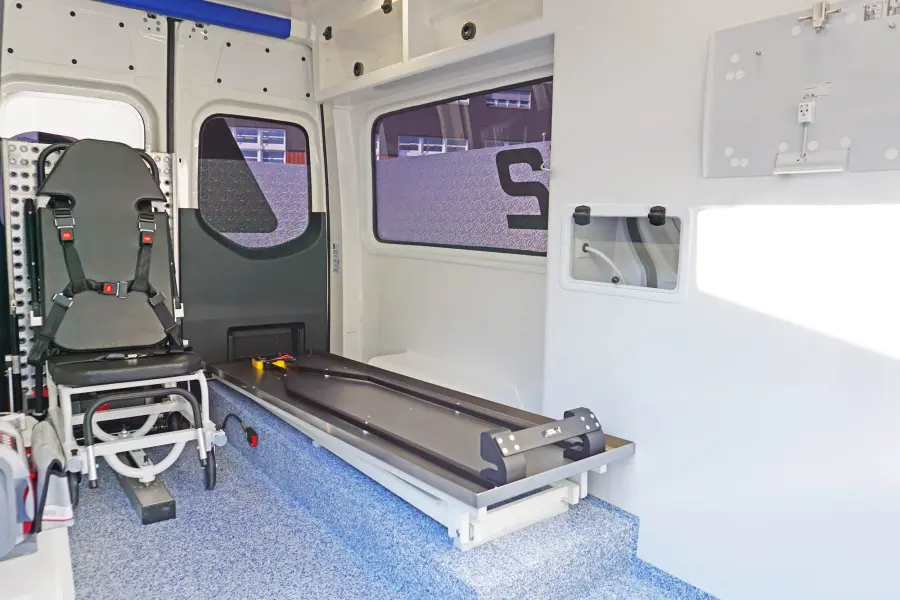 Innenraum eines Spezialfahrzeugs mit montiertem Tragensystem und klappbarem Sitz.