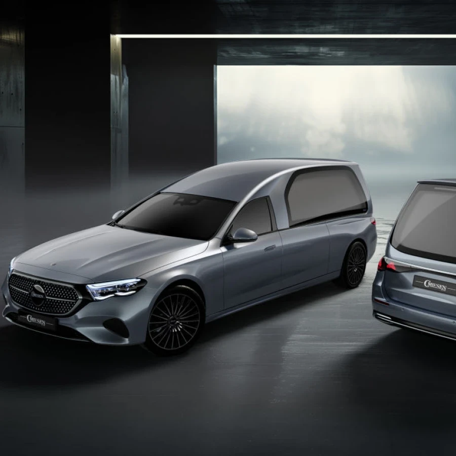 Zwei silberne Bestattungswagen in moderner Halle.