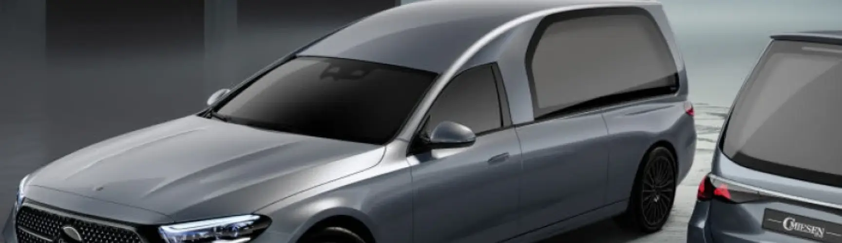 Zwei silberne Bestattungswagen in moderner Halle.