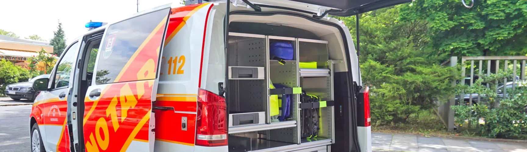 Notarztwagen mit geöffneter Heckklappe und Einsatzausrüstung