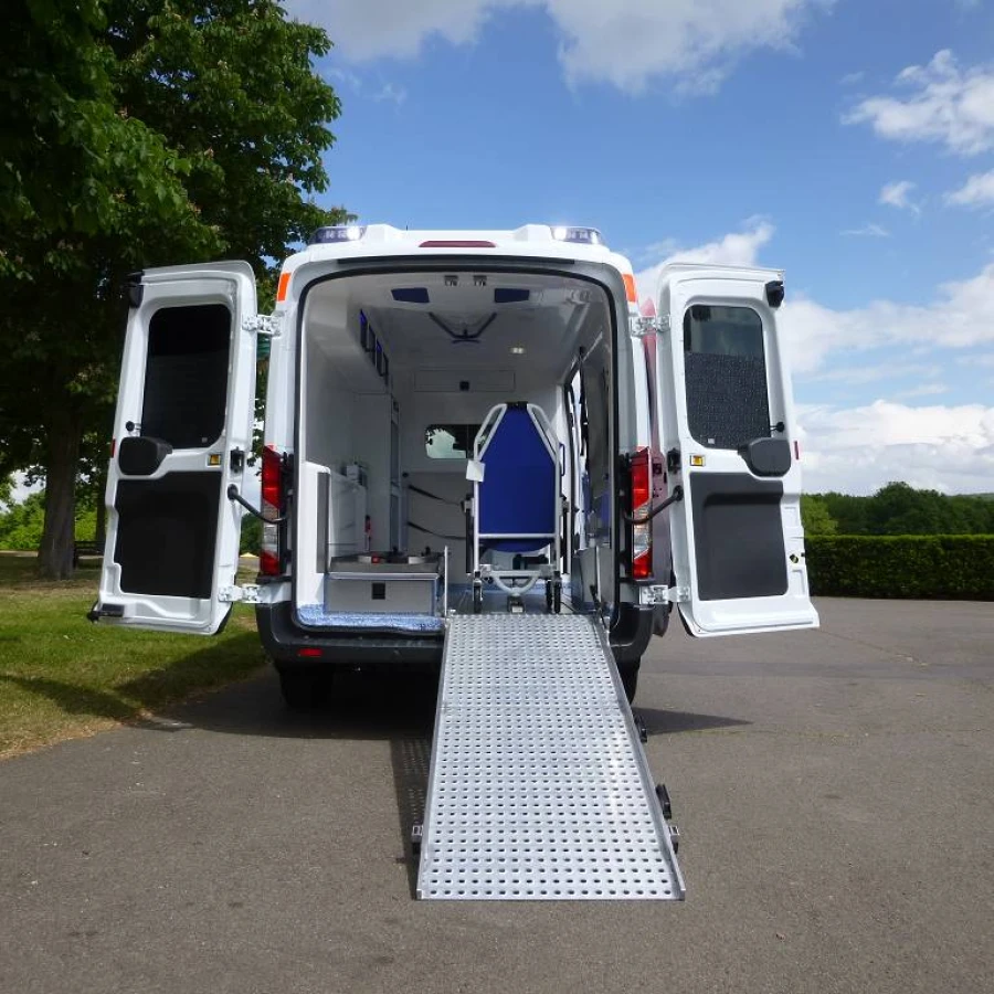 Heckansicht eines Krankenwagens mit geöffneter Rampe und Blick in den hellen Innenraum mit medizinischer Ausstattung.