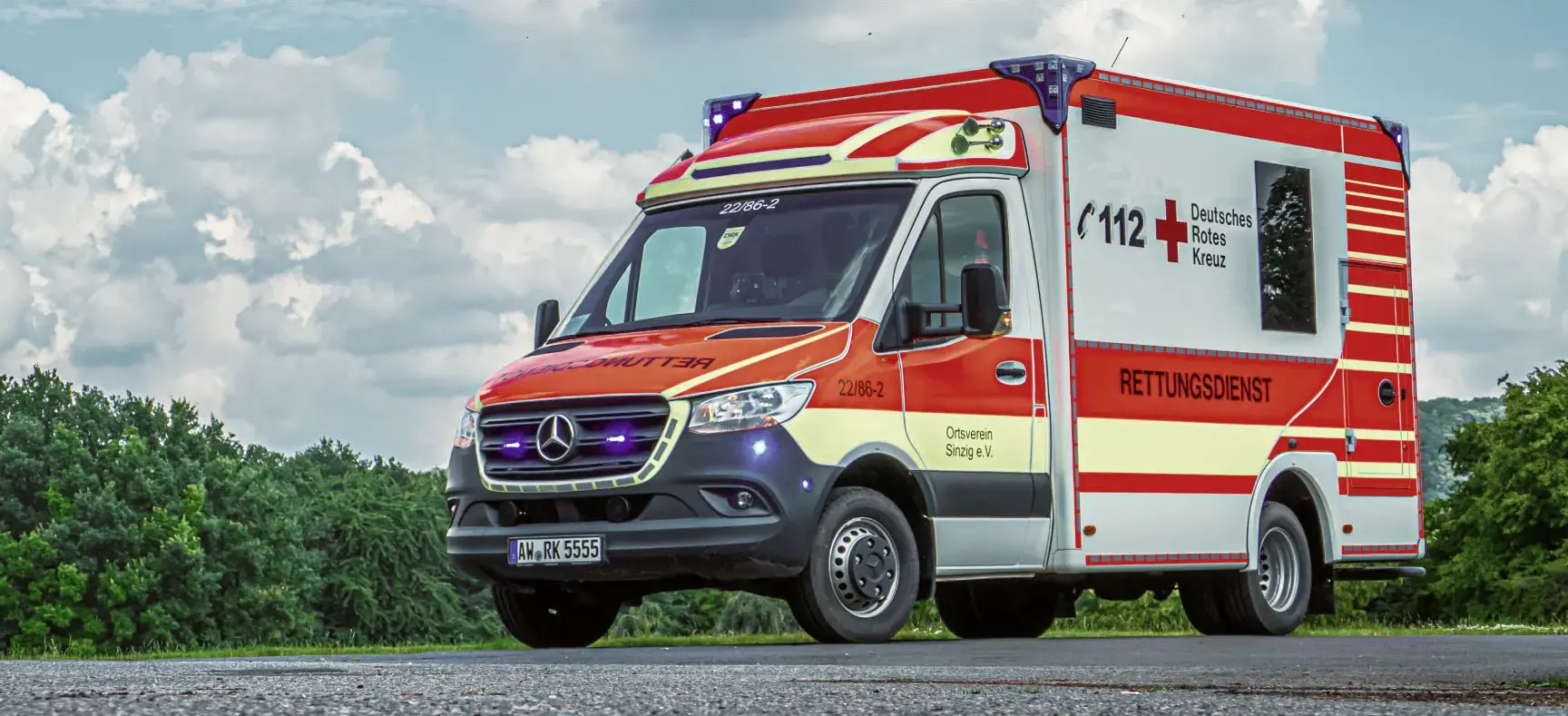 Rettungswagen des DRK auf Landstraße bei Tageslicht