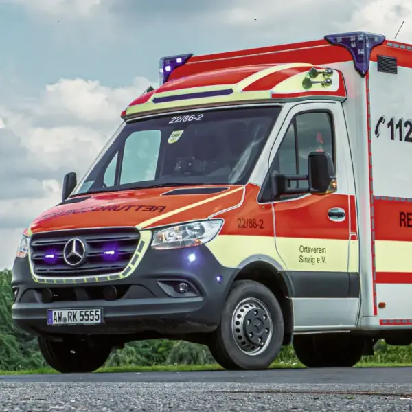 Rettungswagen des DRK auf Landstraße bei Tageslicht