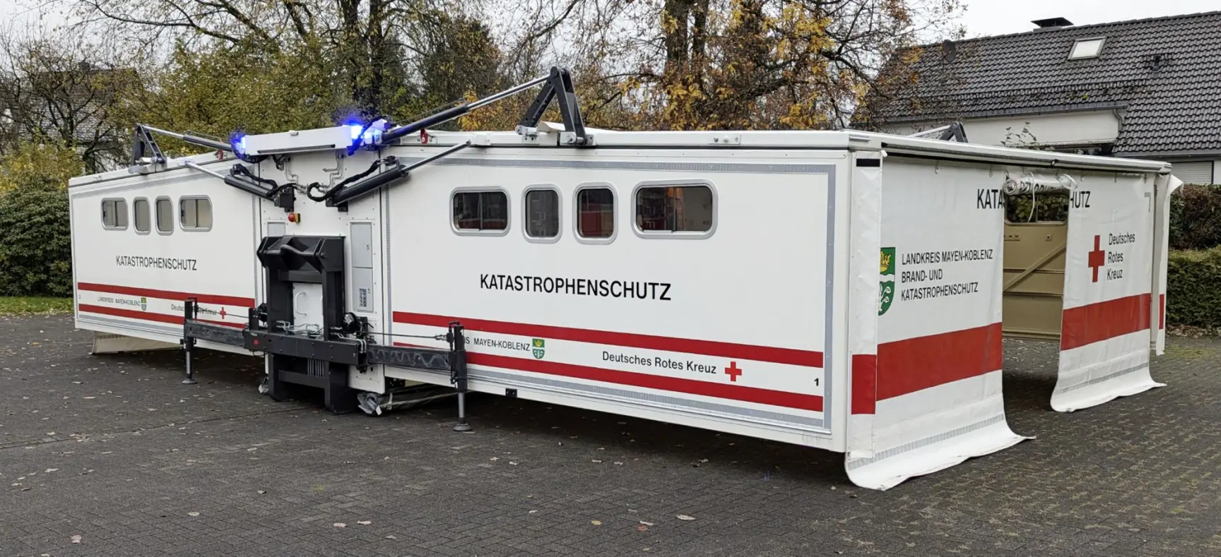 Ausgefahrener Katastrophenschutz-Container des Deutschen Roten Kreuzes mit seitlich ausgeklappten Modulen.