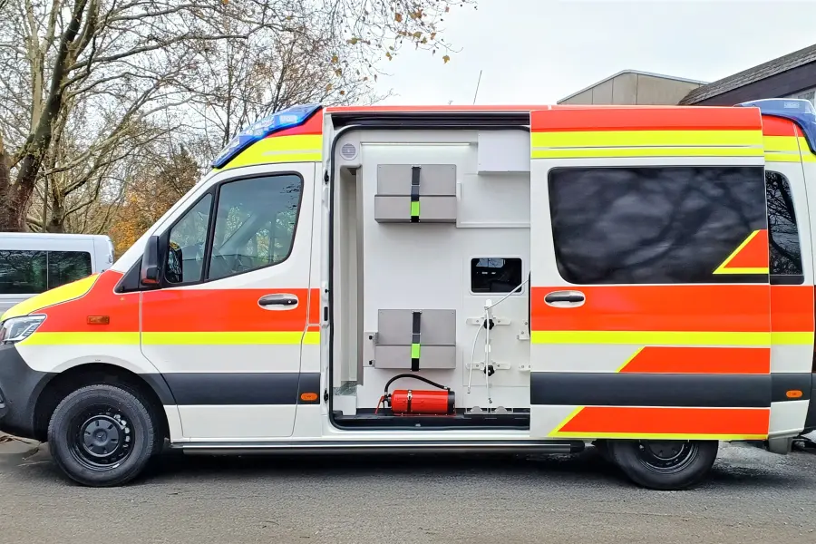 Seitenansicht eines Rettungswagens mit geöffneter Schiebetür und Blick auf die Innenausstattung